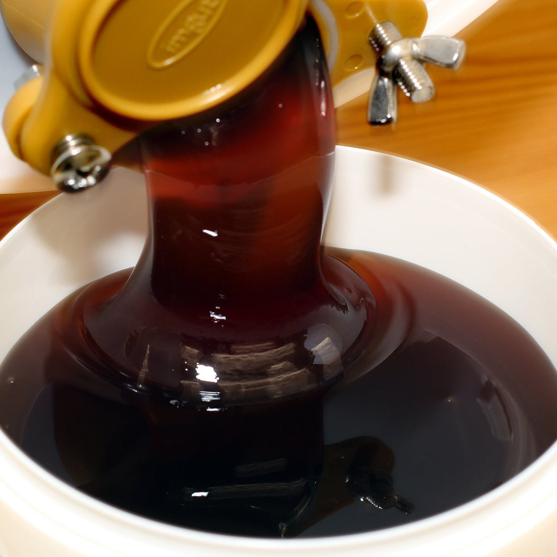 Kastanienhonig dunkelbraun fluessig beim Abfuellen — herber Waldhonig naturbelassen — Mishas Honey